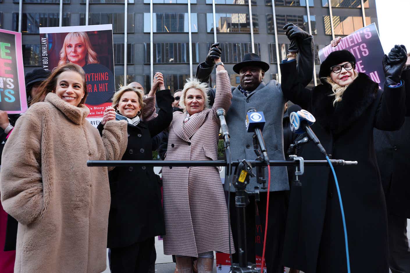 Attorney Ben Crump raises his hand with former music executive Dorothy Carvello (3rd left) advocate Gretchen Carlson and others in announcing a sexual assault lawsuit on March 08, 2023 in New York City. Carvello held the news conference on International Women's Day to announce the lawsuit. Carvello claims that she was subjected to conduct constituting sexual offenses under New York Law by former Atlantic Records Chairman Ahmet Ertegun and numerous male executives at Atlantic Records between 1987 and 1990. 