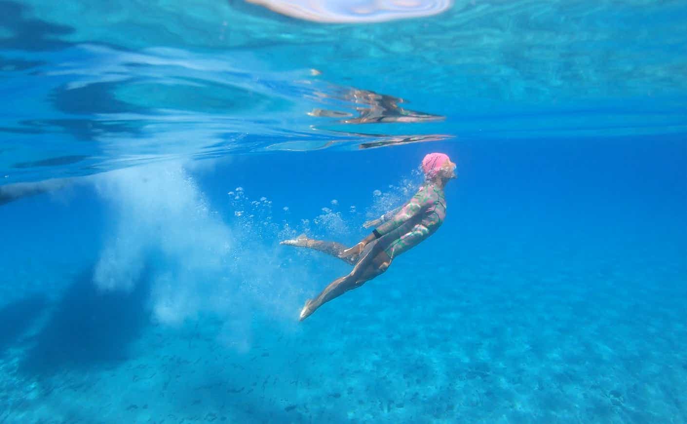 a woman swimming below the surface of the ocean
