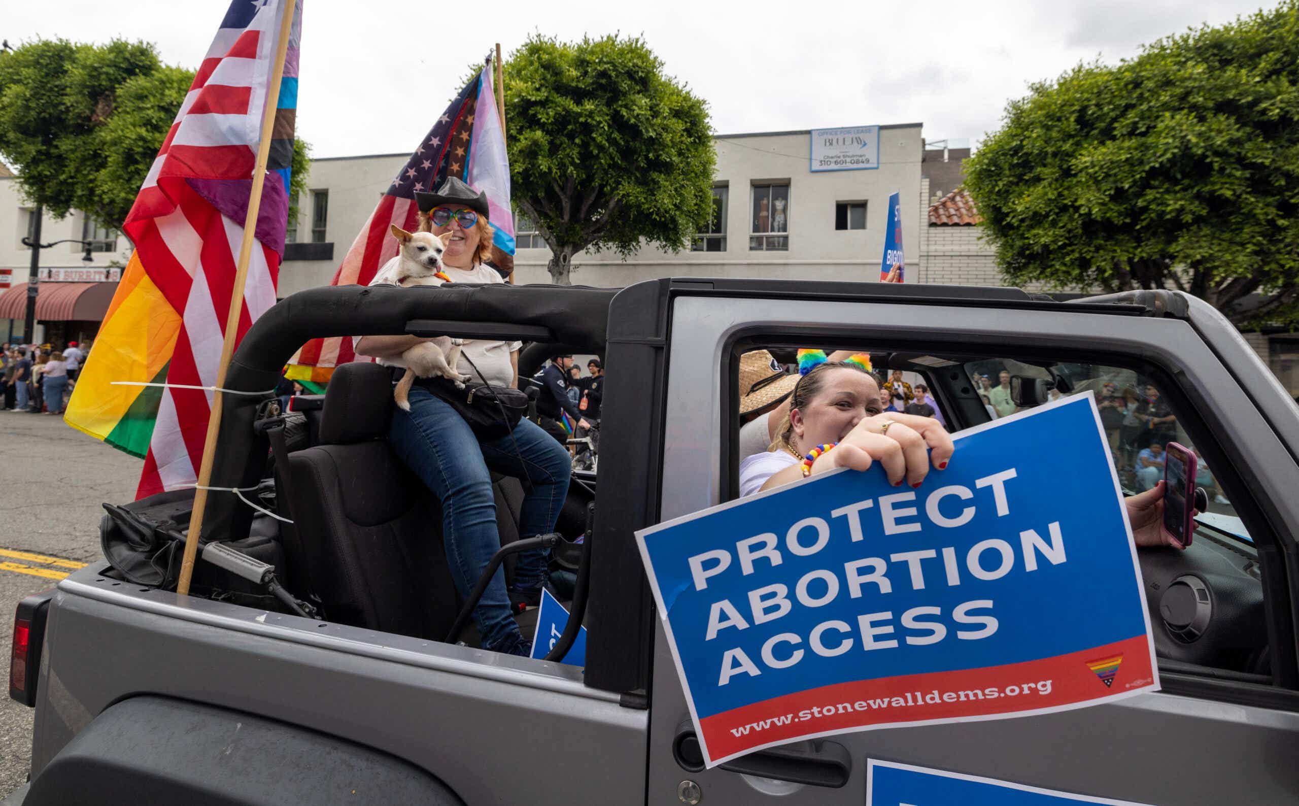 A participant holds a sign calling for the protection of abortion access during the annual LA Pride Parade
