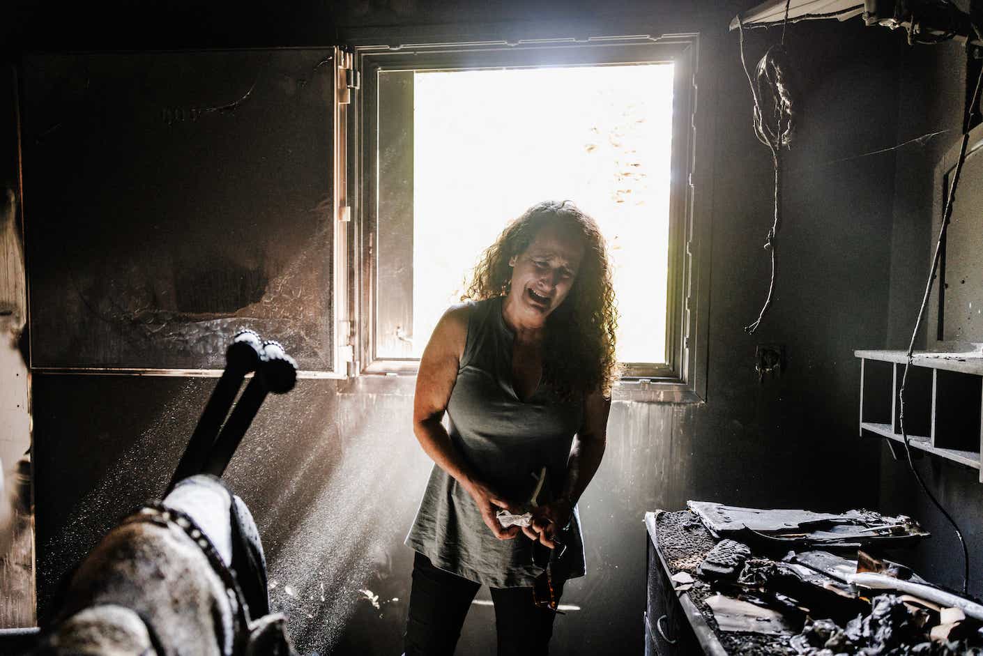 Hadas Kalderon, whose two children Erez and Sahar, and their father, Ofir have been kidnapped, and her mother and niece killed, breaks down in tears while looking through the burnt out home of her late mother Rina Sutzkever on October 30, 2023 in Kibbutz Nir Oz, Israel. More than three weeks since Hamas's Oct 7 attacks in Israel, which killed 1,400 according to Israeli authorities, just over half have now been laid to rest, and over four-fifths have been identified. Volunteers continue to identify victims at the country's Shura military facility. (Photo by Dan Kitwood/Getty Images)