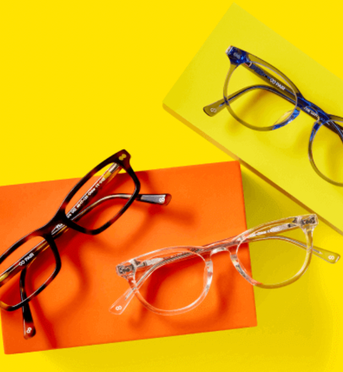 Three pairs of eyeglasses on a yellow and orange background