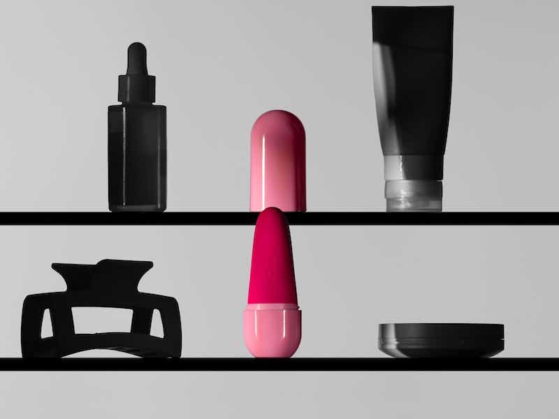 pink bullet vibrator on a shelf with other self care products