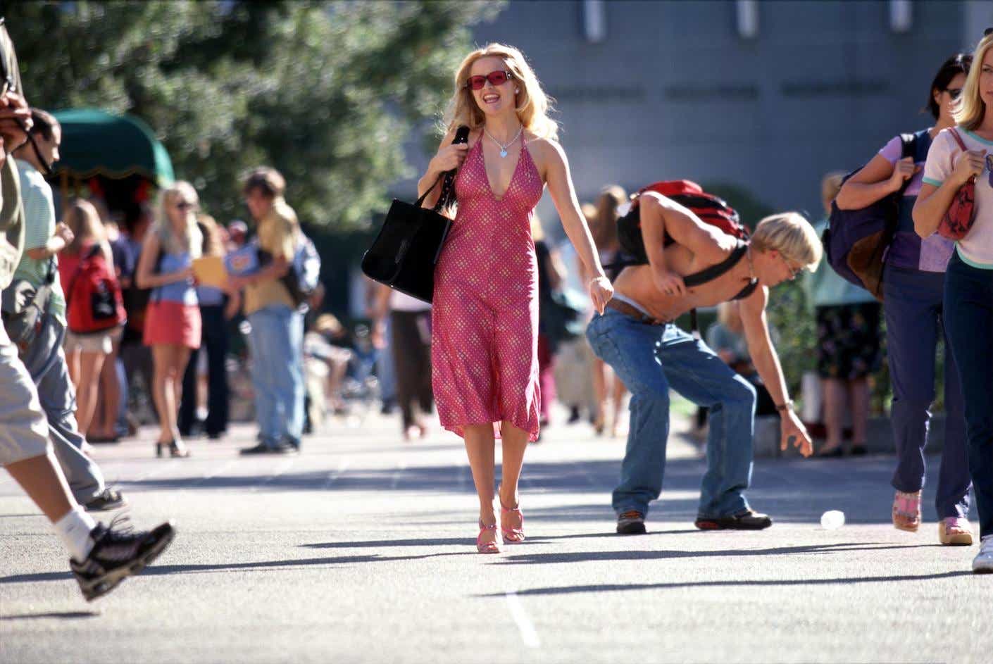 Reese Witherspoon in Legally Blonde walks in a pink dress.