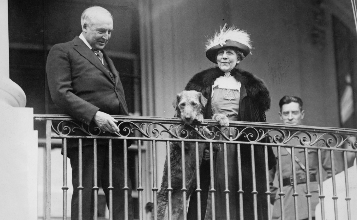 President Warren G. Harding and First Lady Florence Harding watch from a balcony as an annual Easter event takes place on the White House lawn, circa 1922. With them is their pet dog, Laddie Boy.