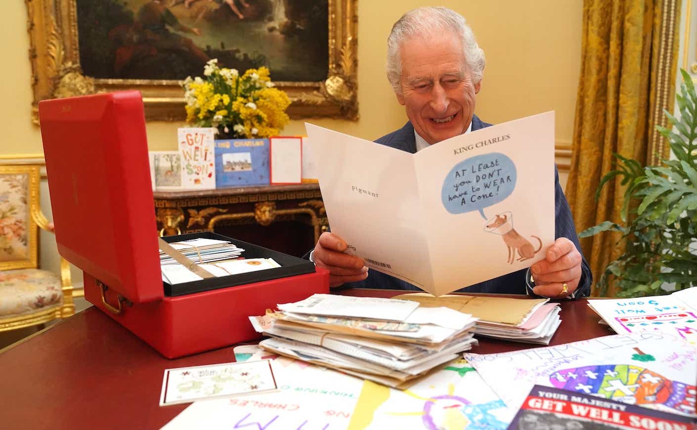 In this photo released on February 23, King Charles III reads cards and messages, sent by well-wishers following his cancer diagnosis, in the 18th Century Room of the Belgian Suite at Buckingham Palace on February 21, 2024 in London, England