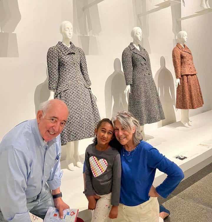 two grandparents and their granddaughter at a museum