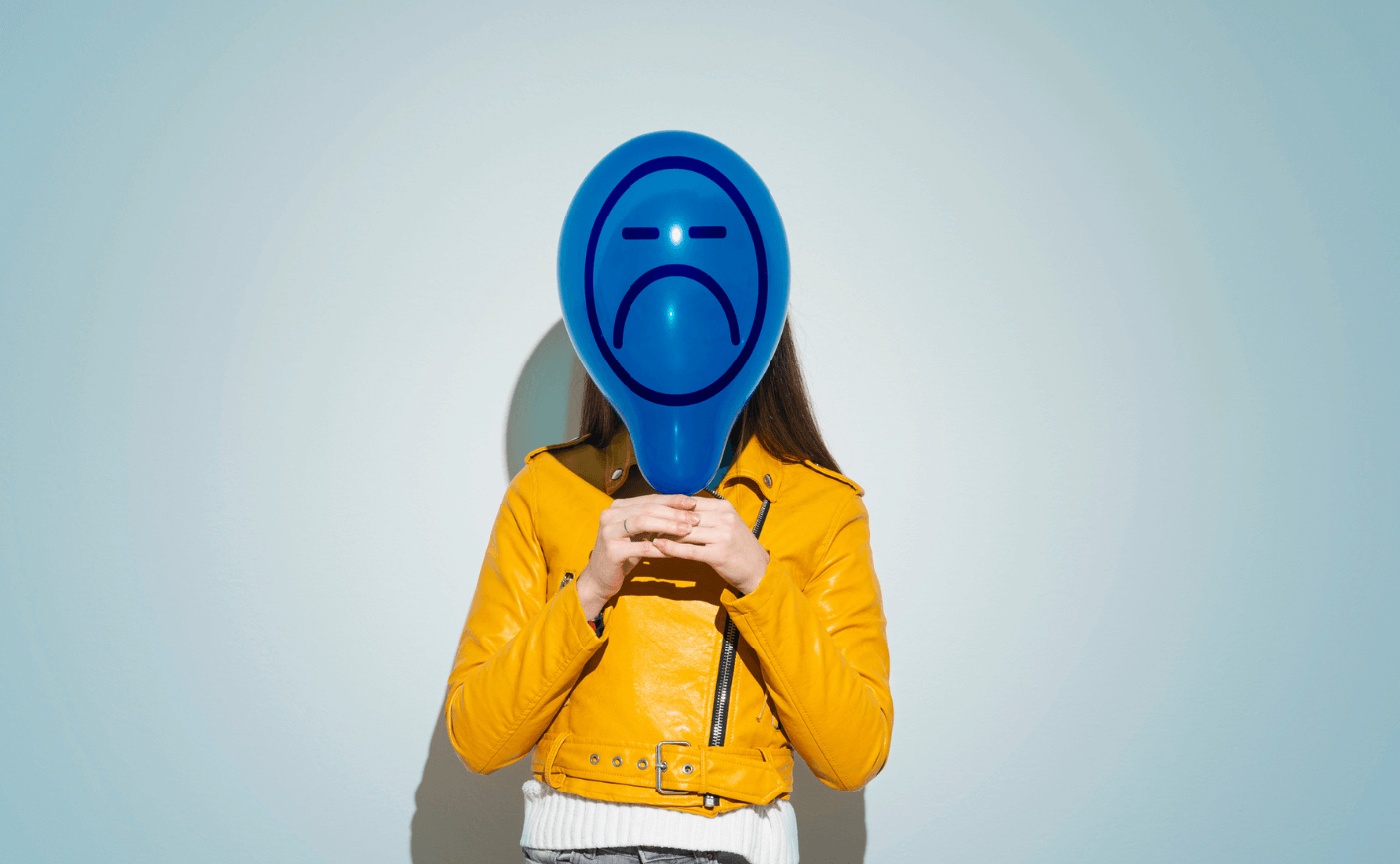 Woman with a sad face balloon