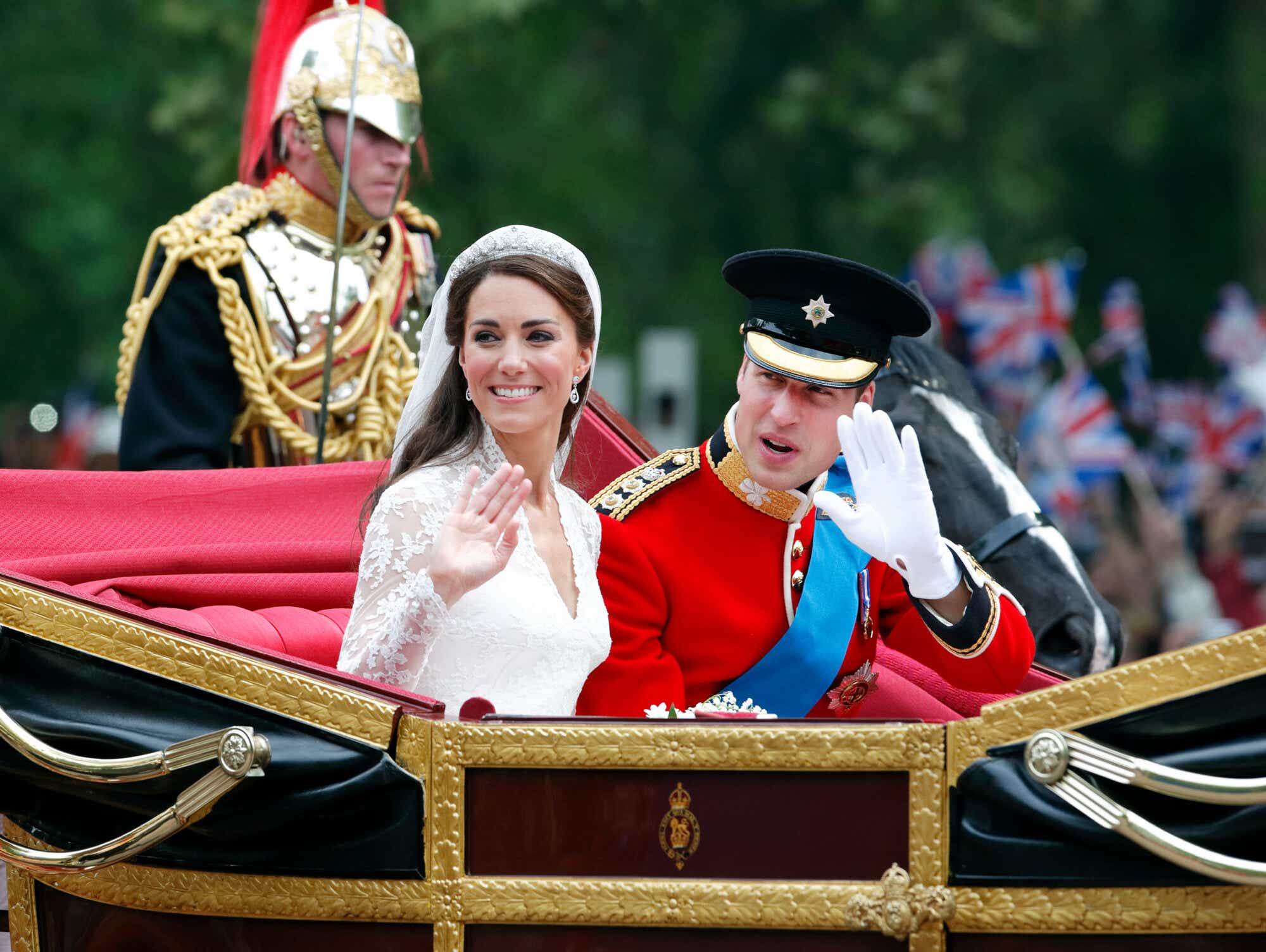 Catherine, Duchess of Cambridge and Prince William, Duke of Cambridge (wearing his red tunic uniform of the Irish Guards, of which he is Colonel) travel down The Mall, on route to Buckingham Palace, in the 1902 State Landau horse drawn carriage following their wedding ceremony at Westminster Abbey on April 29, 2011 in London, England. 