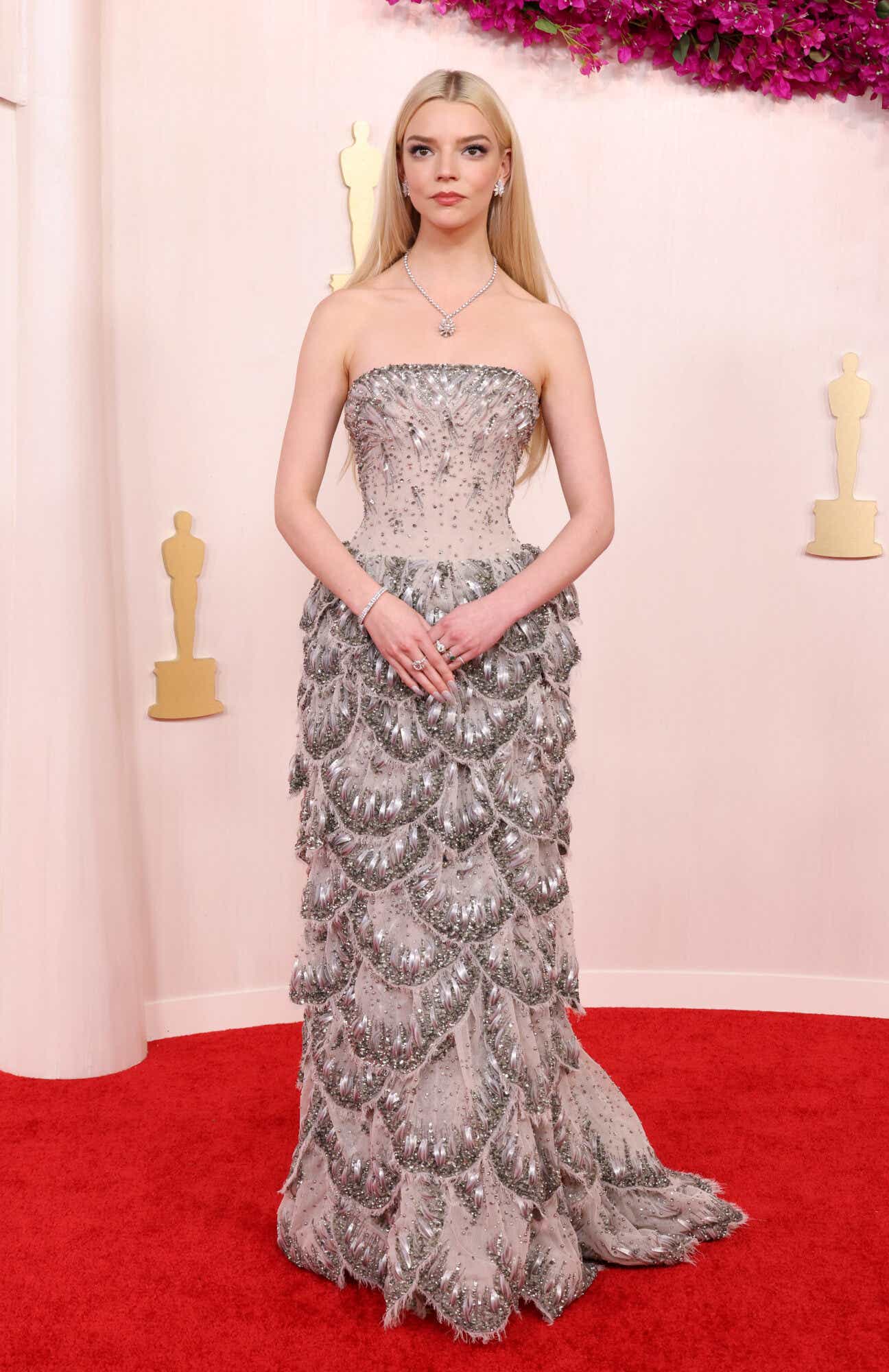 Anya Taylor-Joy on the Oscars red carpet wearing a 1920's inspired gown that has a beaded bodice and a bejeweled petal skirt.