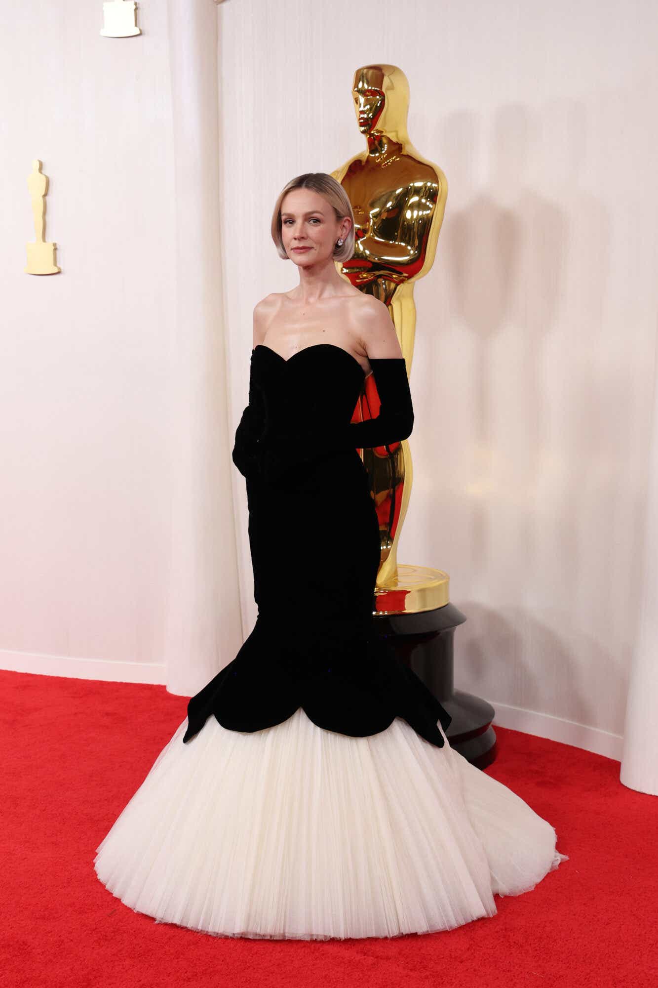 Carey Mulligan arrives at the Oscars weraing a strapless black trumpet gown with a white tulle skirt and matching black gloves.