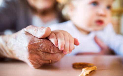 Close up of grandmother holding grandson hand and storing dried apples.