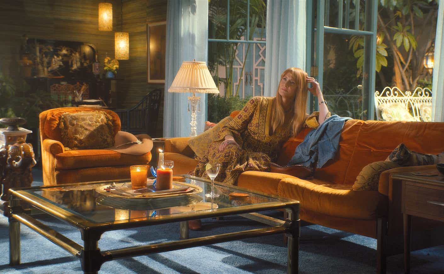 laura dern laying on a couch on the set of Palm Royale