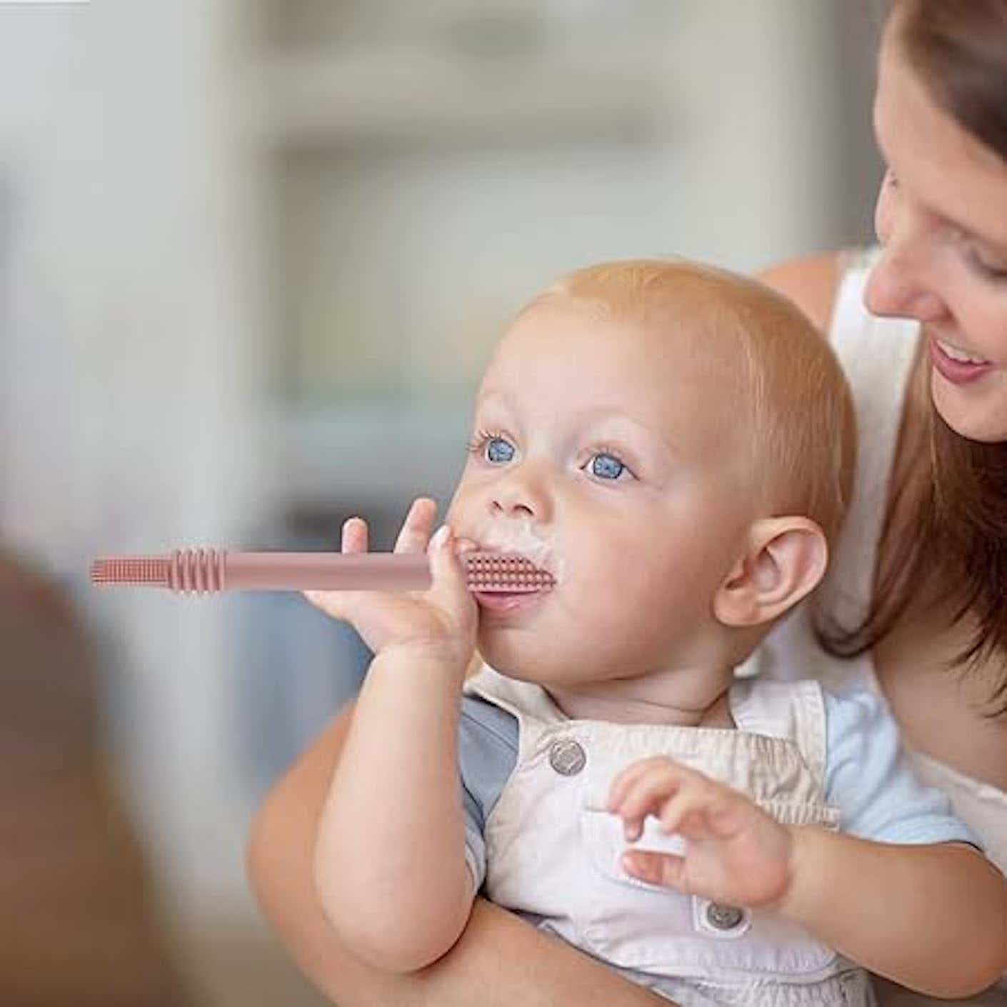 A baby teething on a silicone tube.