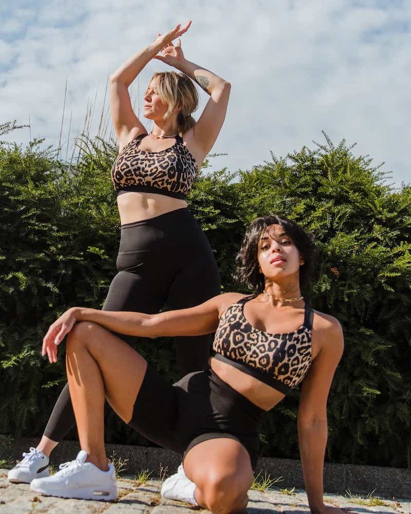 two women wearing leopard sports bras