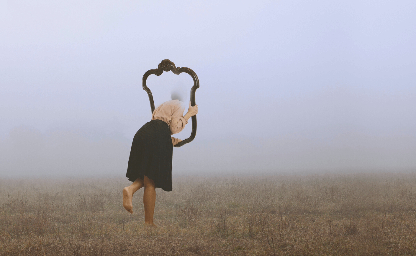 woman looking through a mirror with fog