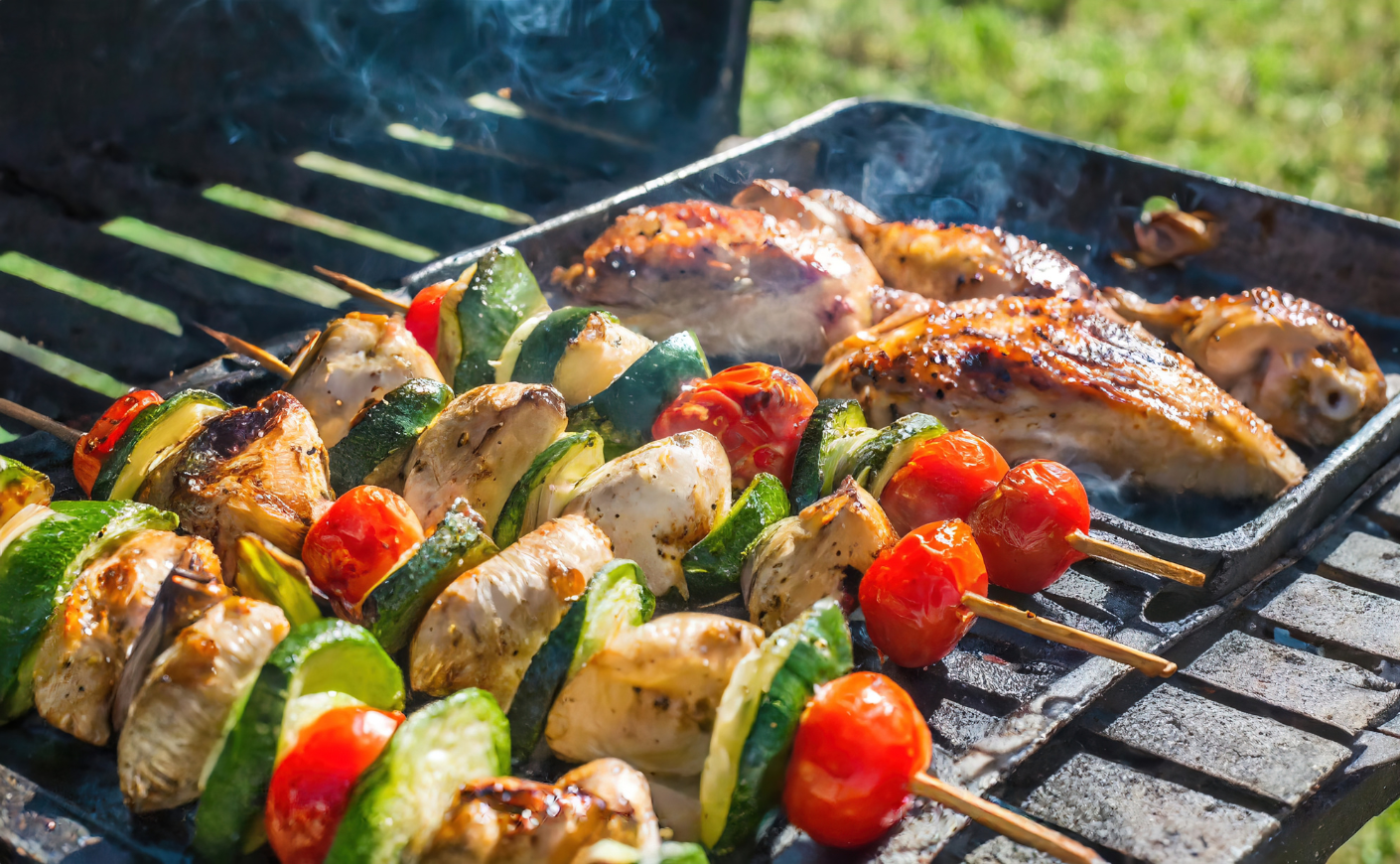 Vegetables and meat cooking on a grill