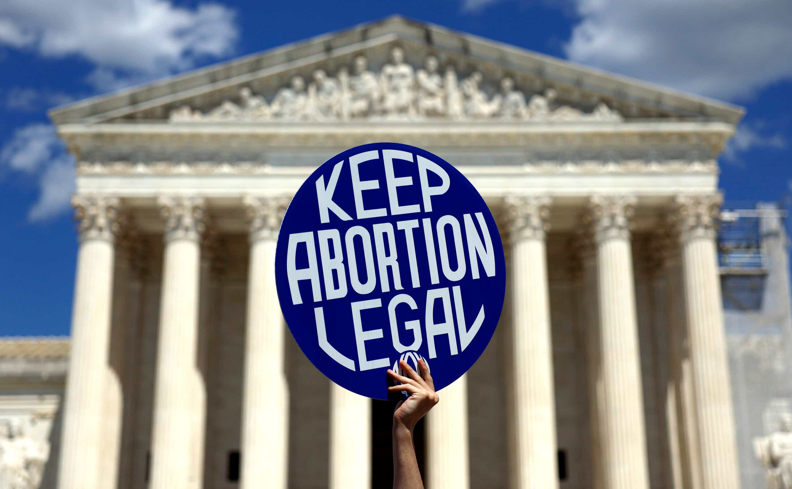 Hand holding sign saying "keep abortion legal" in front of the Supreme Court