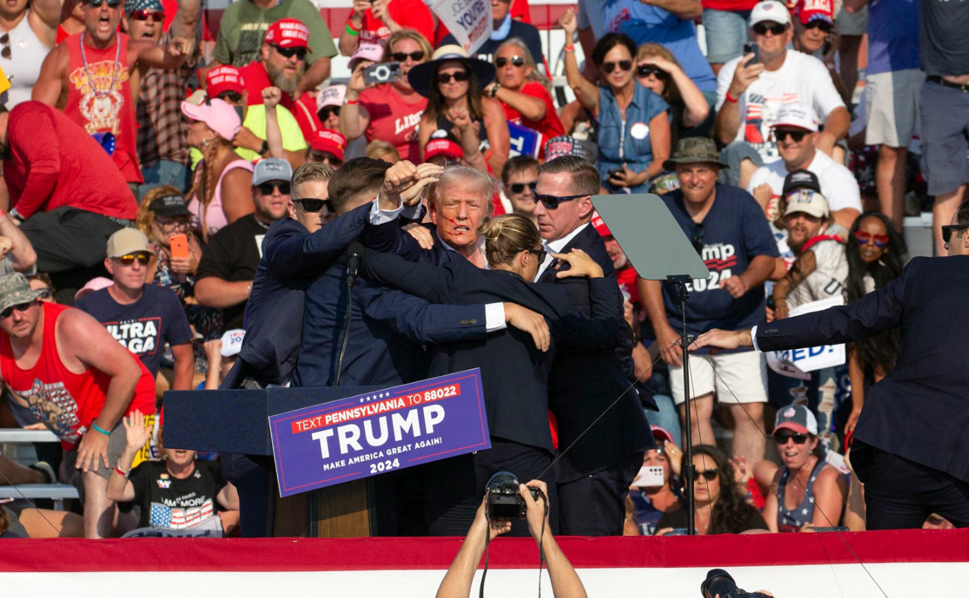 Secret Service agents form a protective bubble around Donald Trump after shots rang out at his rally in Pennsylvania.