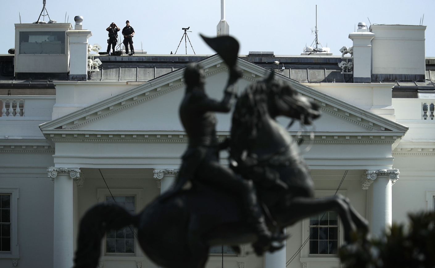 Secret Service agents observe the surrounding area from the roof of the White House on May 20, 2016, after an armed man was shot on the premises.