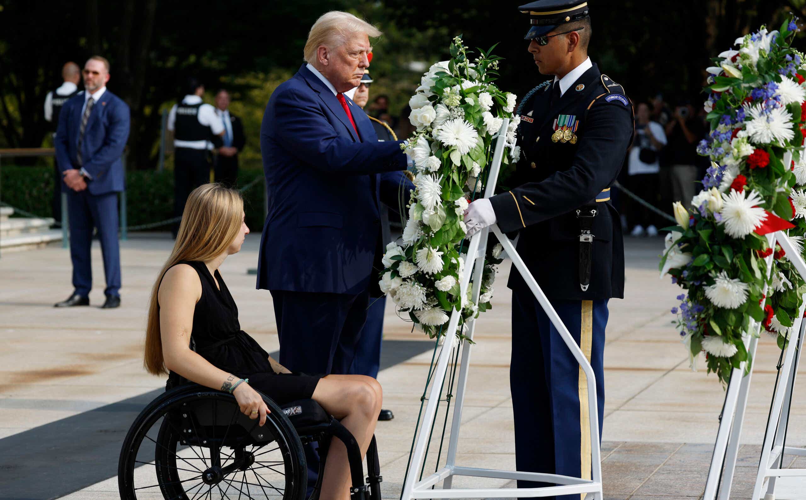 Trump lays a wreath alongside Marine Cpl. Kelsee Lainhart (Ret.), who was injured at the Abbey Gate Bombing, during a wreath-laying ceremony at the Tomb of the Unknown Soldier at Arlington National Cemetery