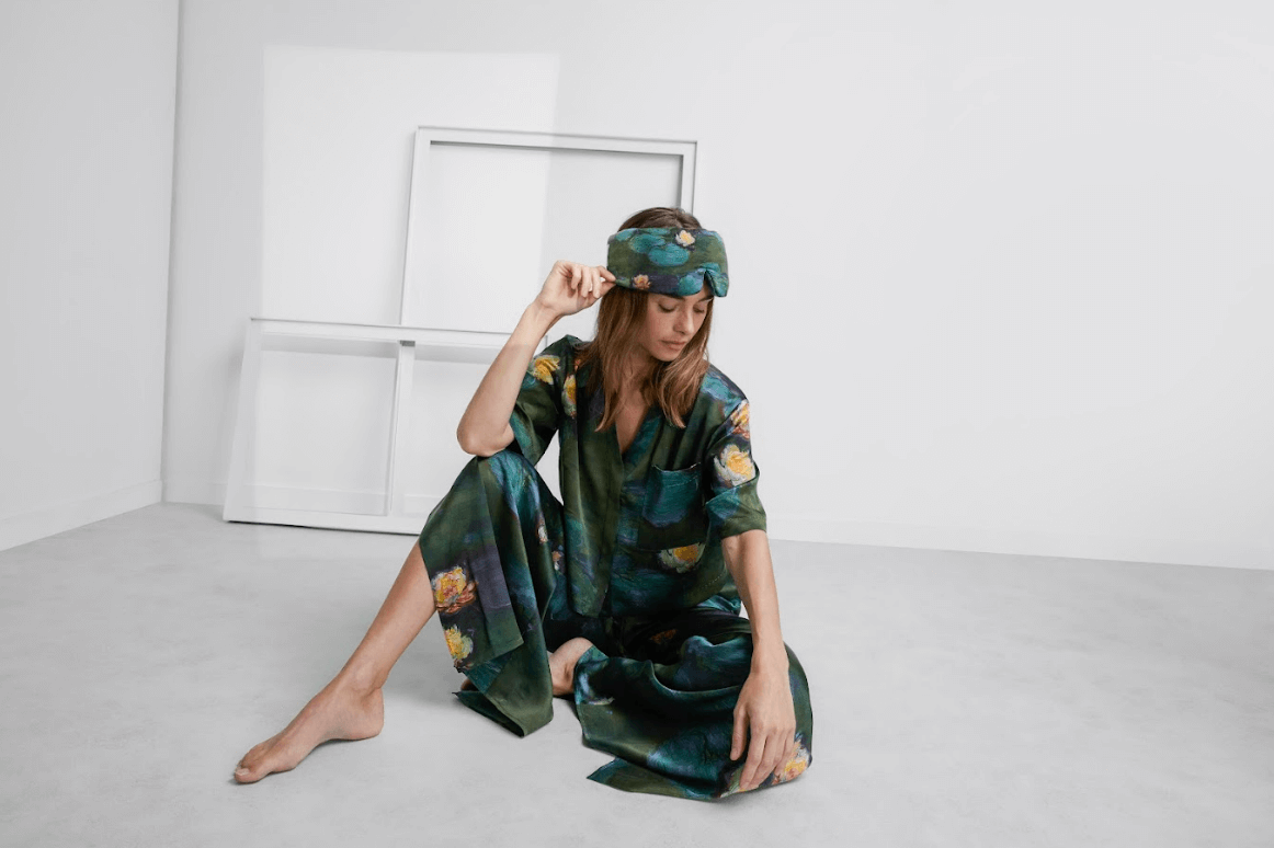 Model wearing the Lunya x LACMA waterlilies silk pajama set and mask. 