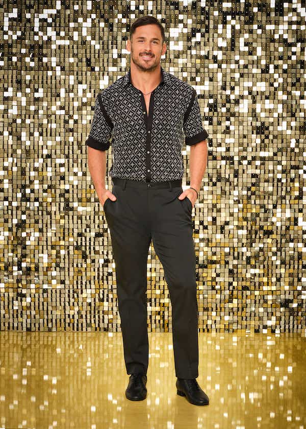 Danny Amendola in a short-sleeve button down with a geometric silver pattern, and black pants.