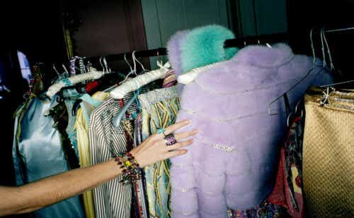 WOMAN SELECTING CLOTHES FROM RAIL, CLOSE-UP