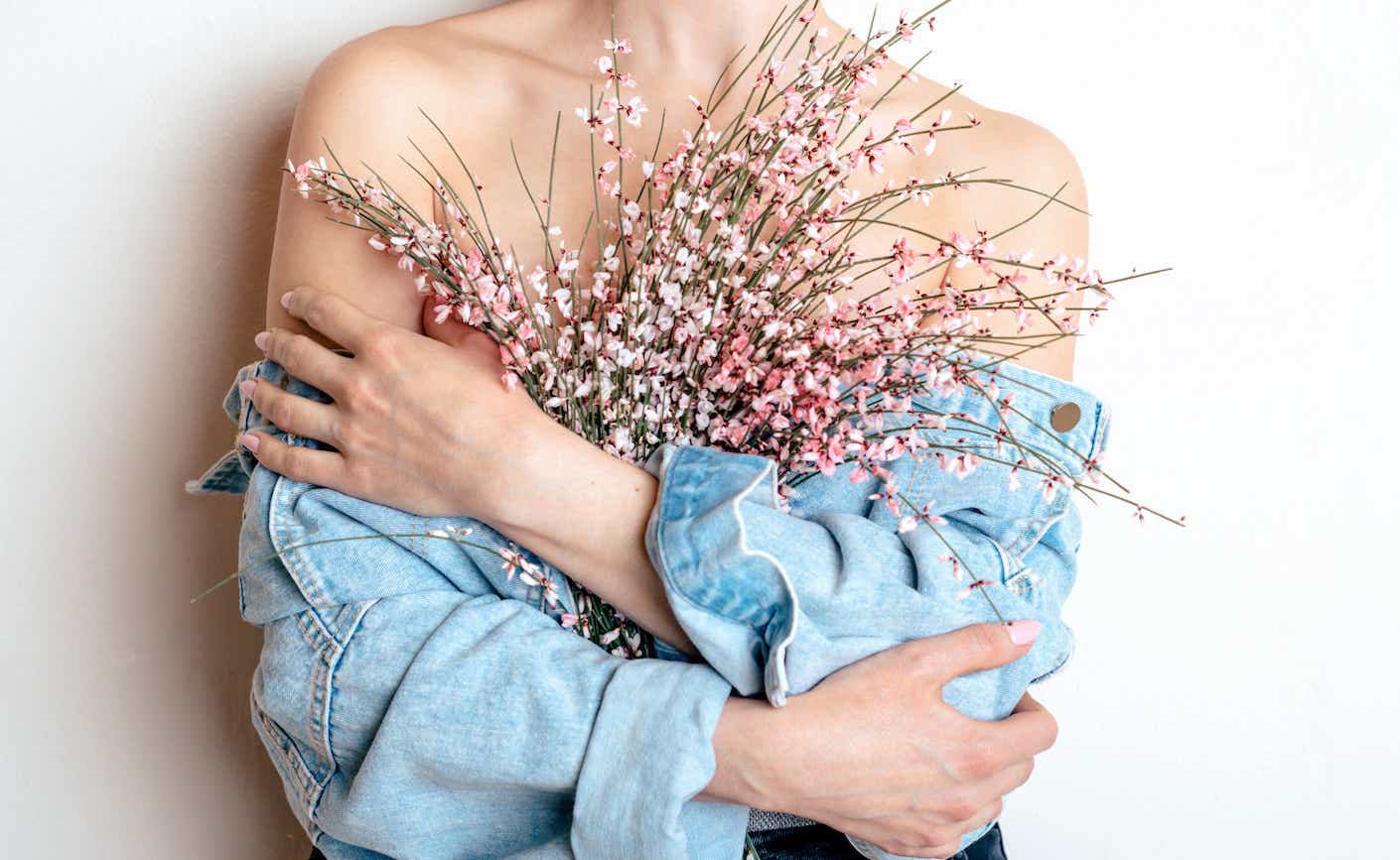 Photo of woman holding pink flowers over her chest