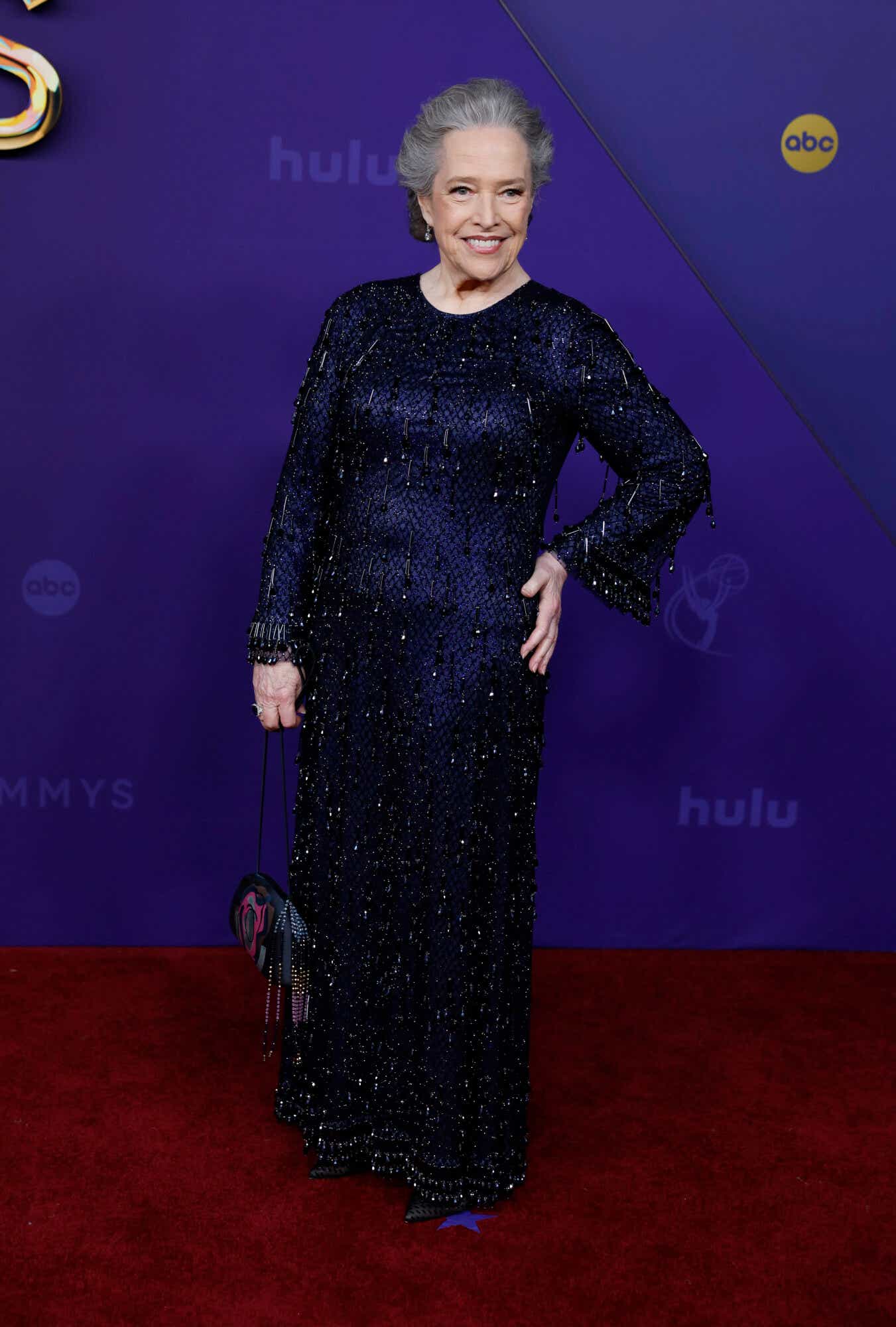 Kathy Bates sports a sequined 1920's-inspired navy blue long-sleeve gown.