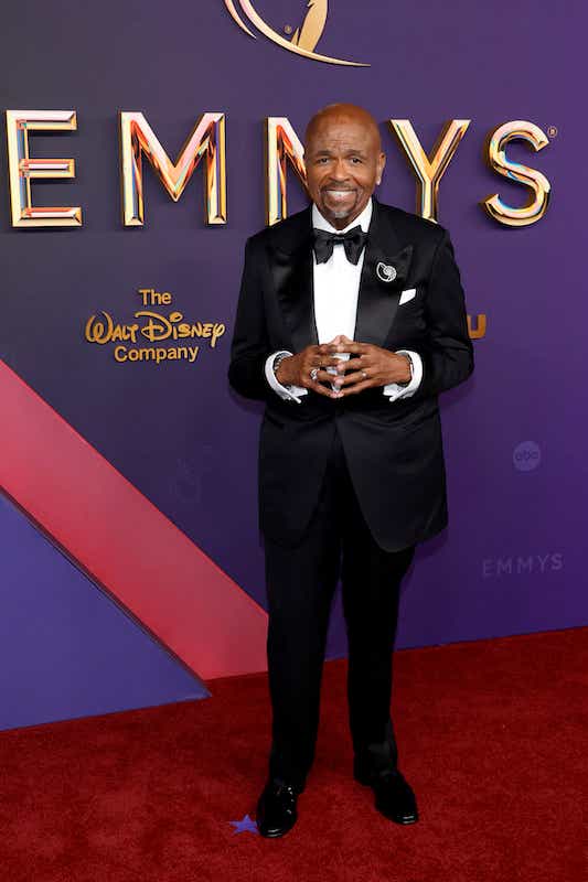 William Stanford Davis attends the Emmys in a black tux, white shirt, black bow-tie, and pin depicting a spiral.