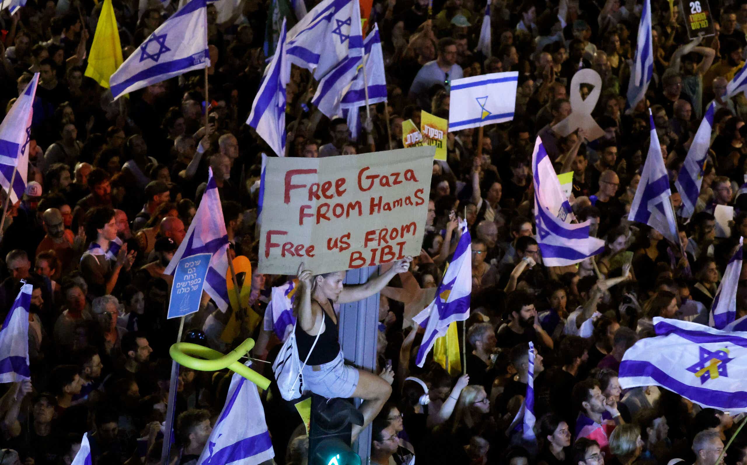 A protester holds up a sign as they join a crowd gathered to demand a Gaza hostages deal