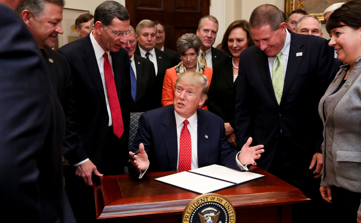 Donald Trump signs an executive order to begin the rollback of environmental regulations put in place by the Obama administration on Feb. 28, 2017.