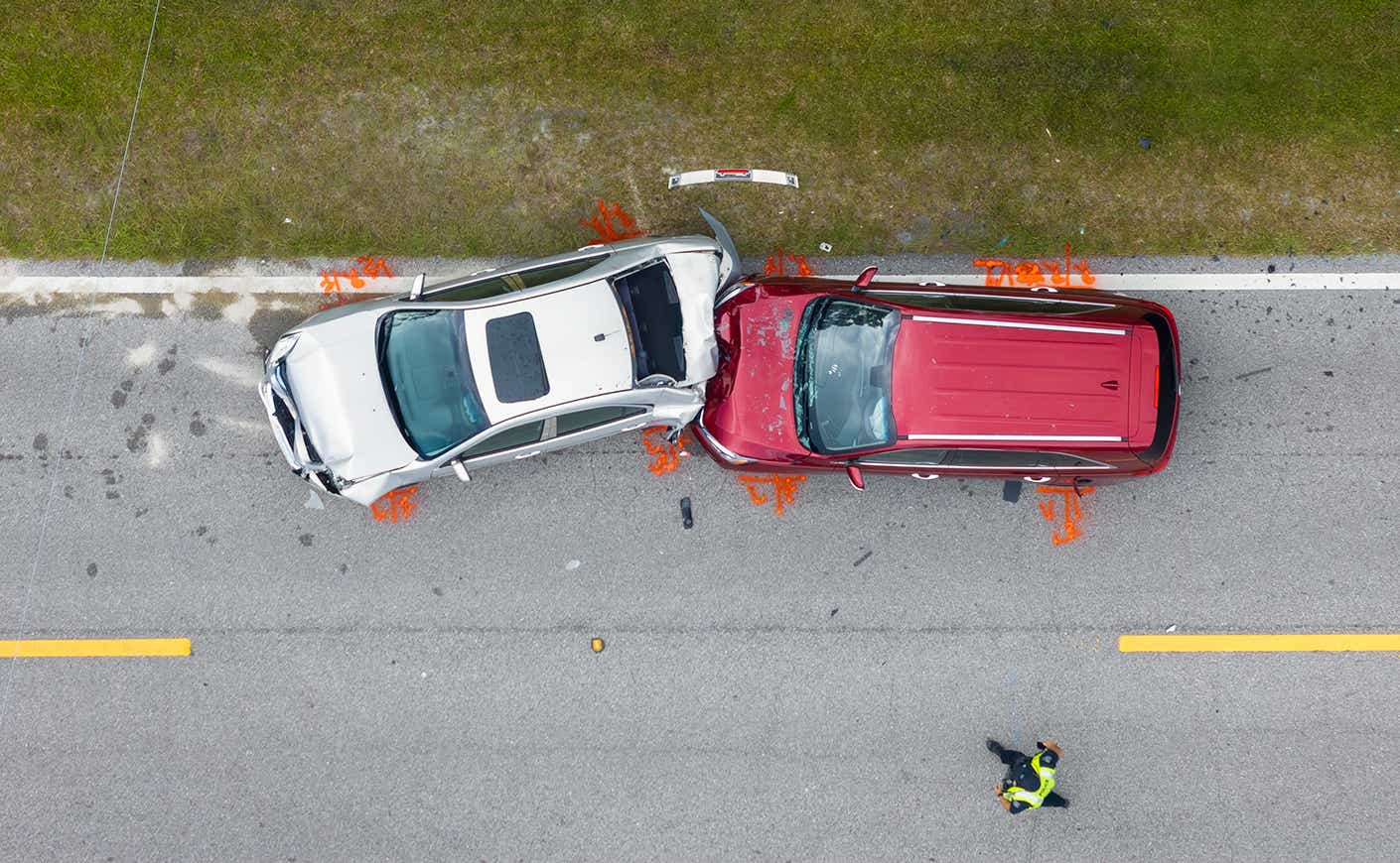 An aerial view of a silver sedan that got rear-ended by a red sedan