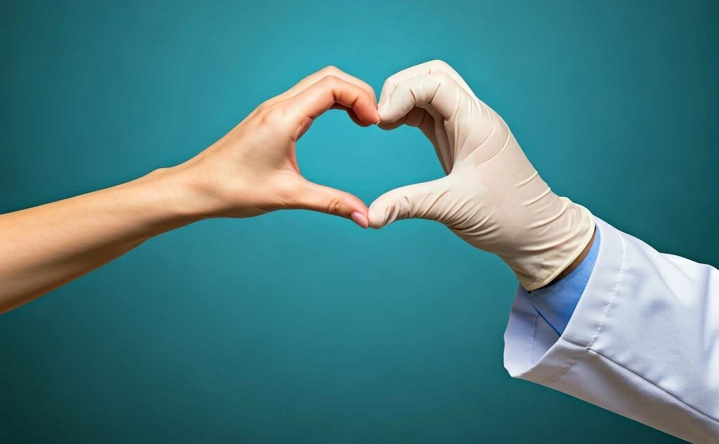 a patient and doctor making a heart with their hands