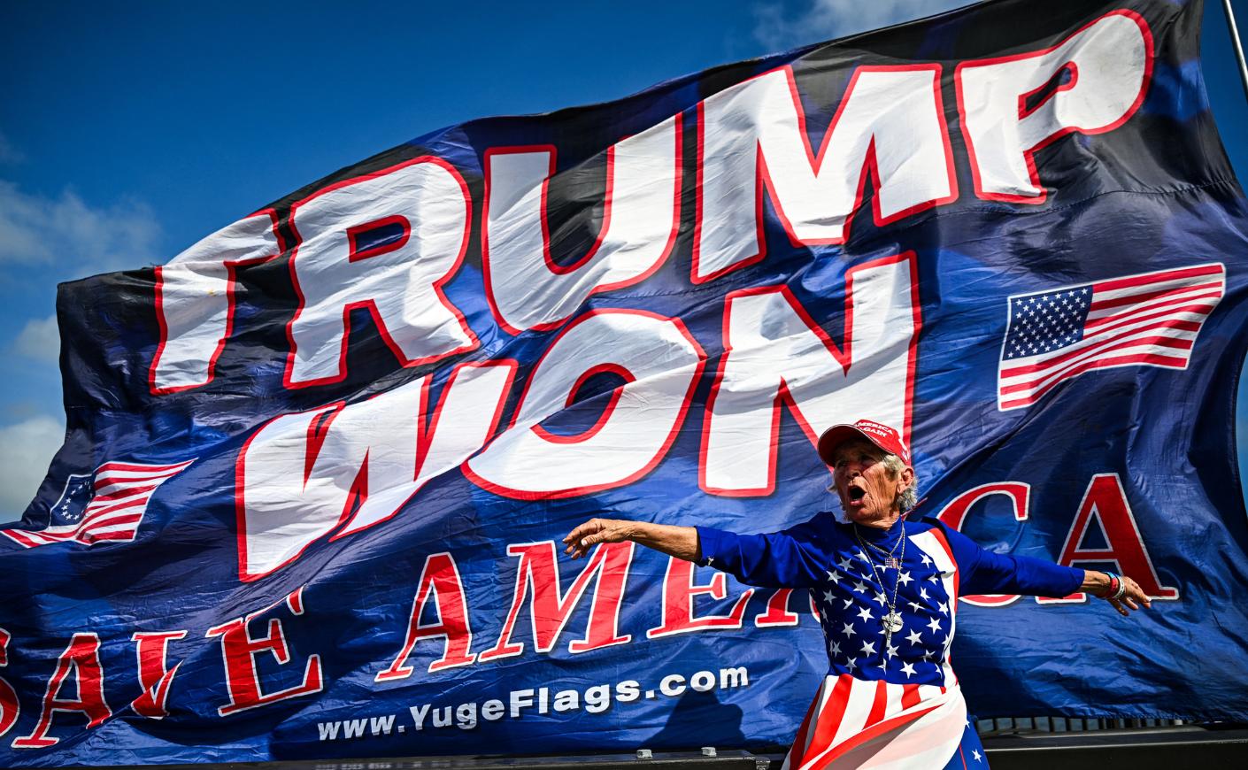 A person standing in front of a "Trump Won" flag