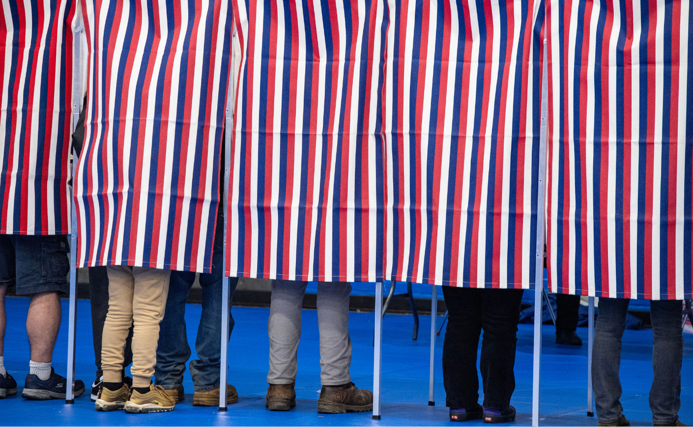 People standing in voting booths