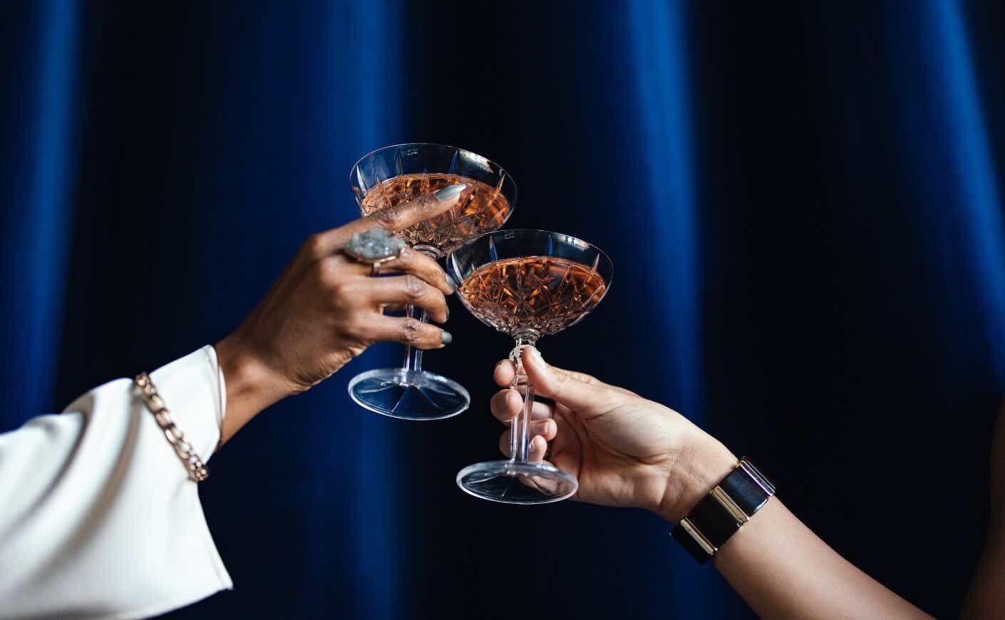 two arms toasting with wine glasses