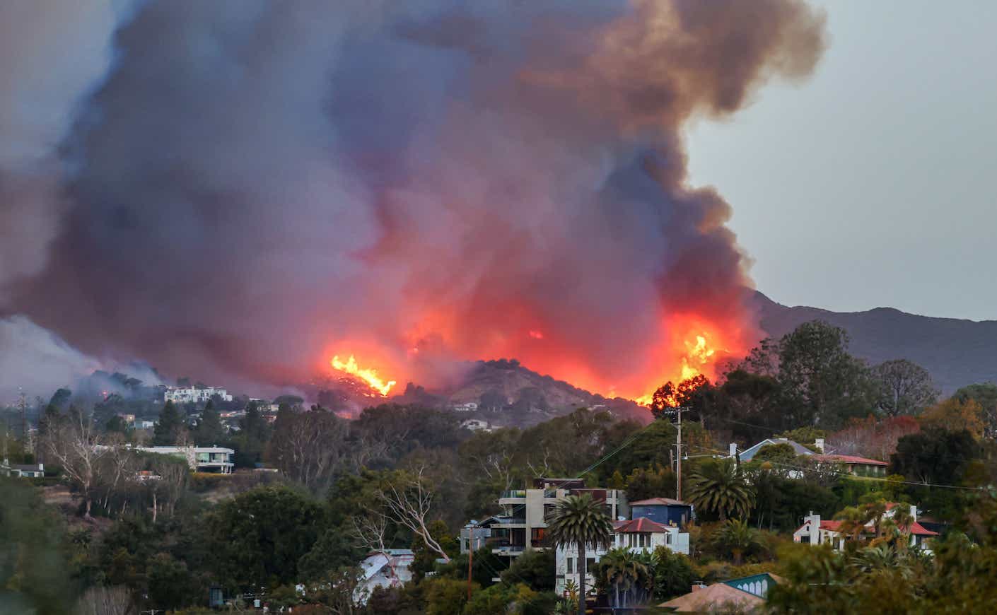 Smoke and flames from the Palisades Fire fill the sky as seen from the Pacific Palisades neighborhood of Los Angeles, California on January 07, 2025