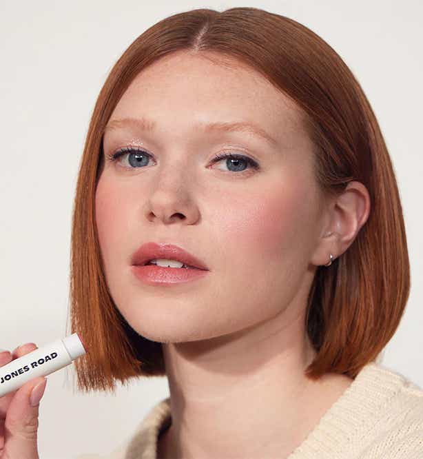 woman putting on lipstick