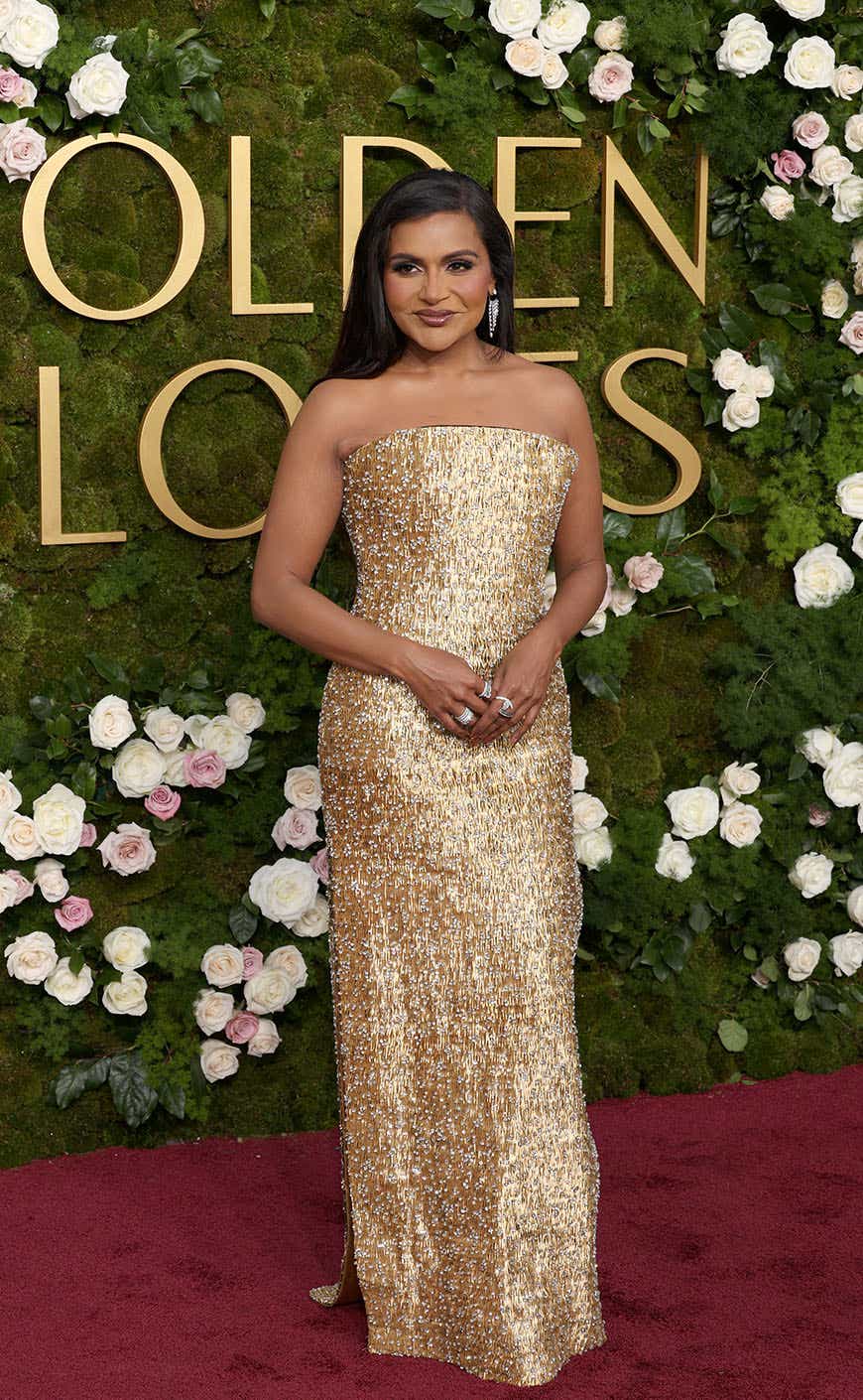 Mindy Kaling wears a bedazzled gold strapless gown on the Golden Globes red carpet