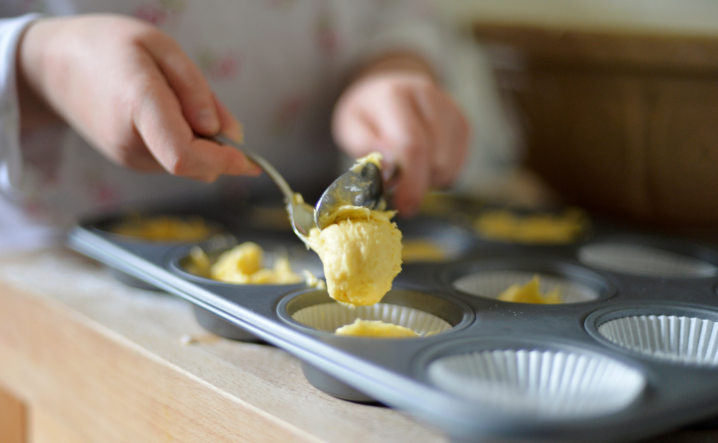 Woman putting batter into a muffin pan