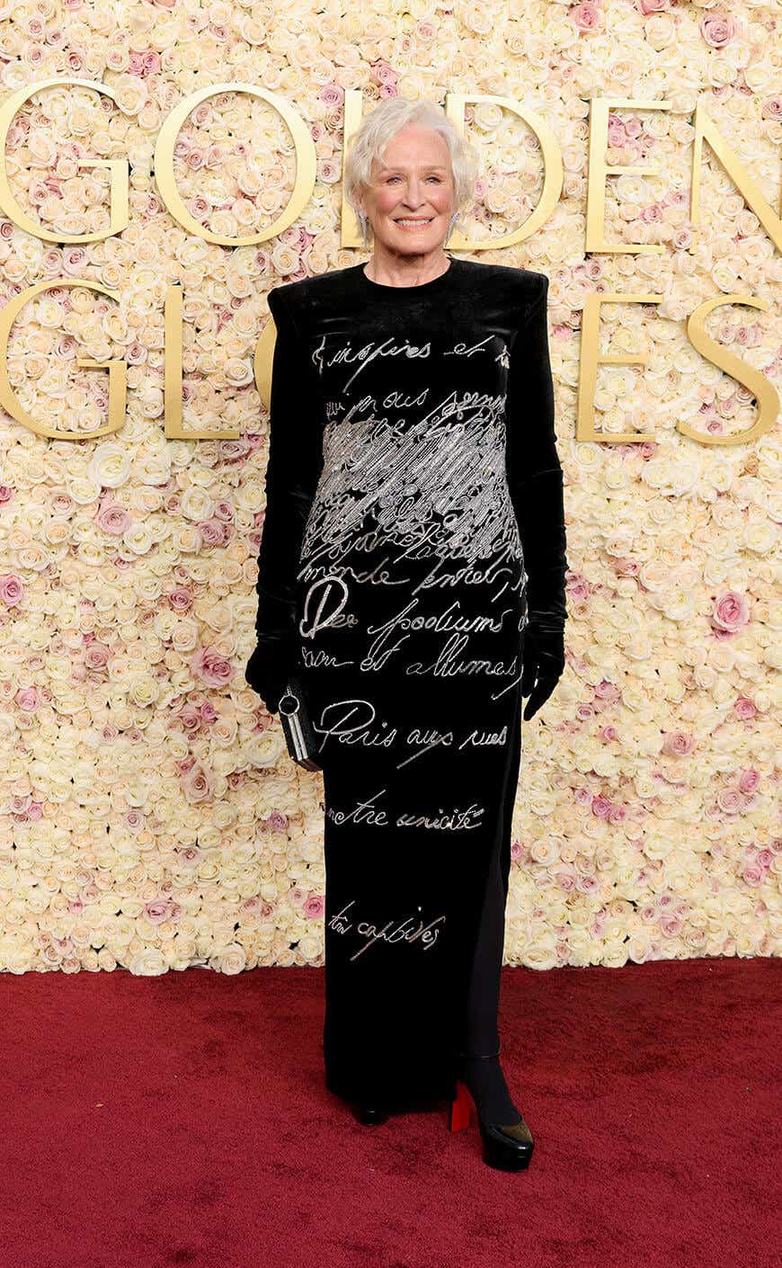 Glenn Close wears a black dress with script writing embroidered on it