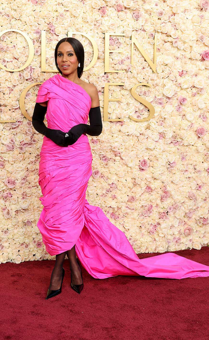 Kerry Washington wears a hot pink rushed one-shoulder gown and black gloves.