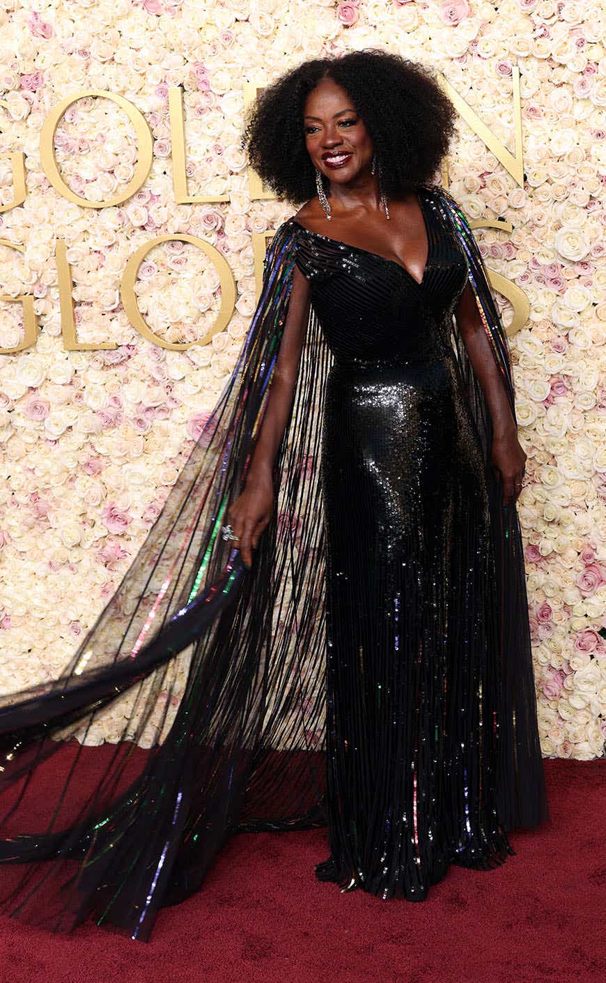 Viola Davis wears a sequined black gown with a sequined cape to the Golden Globes.