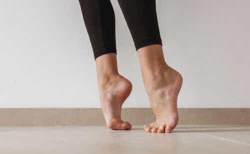 Woman stands barefoot on tip-toes