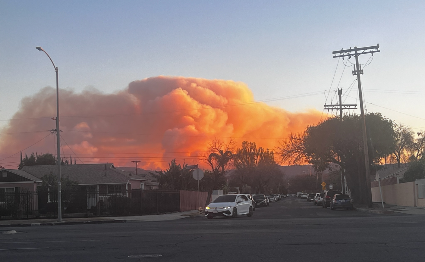 A photo capturing fires in the distance, as seen from the author's neighborhood on the day she evacuated