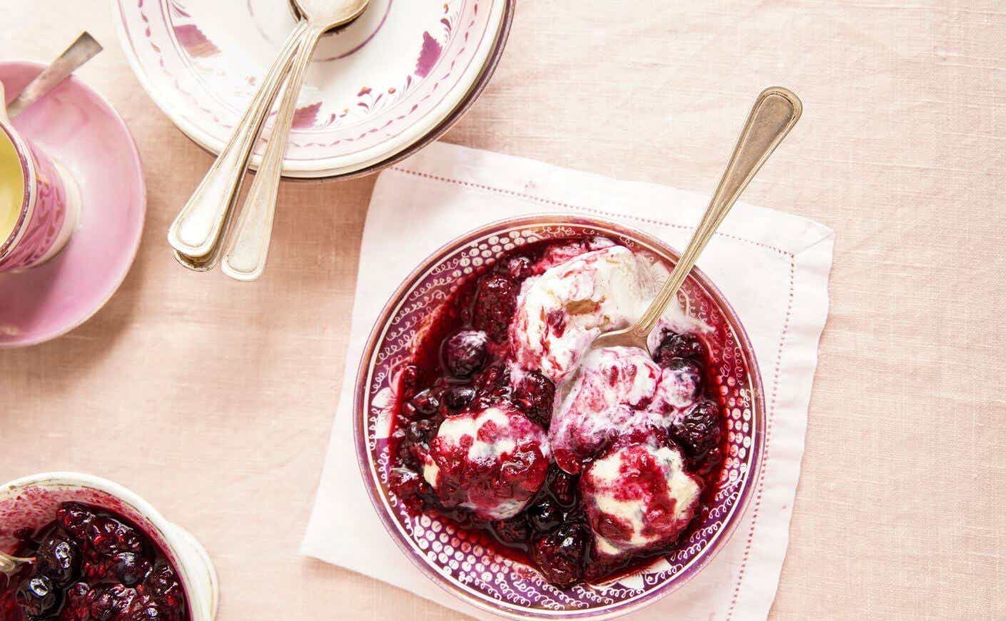 A bowl of fresh berry dumplings with ice cream on top.