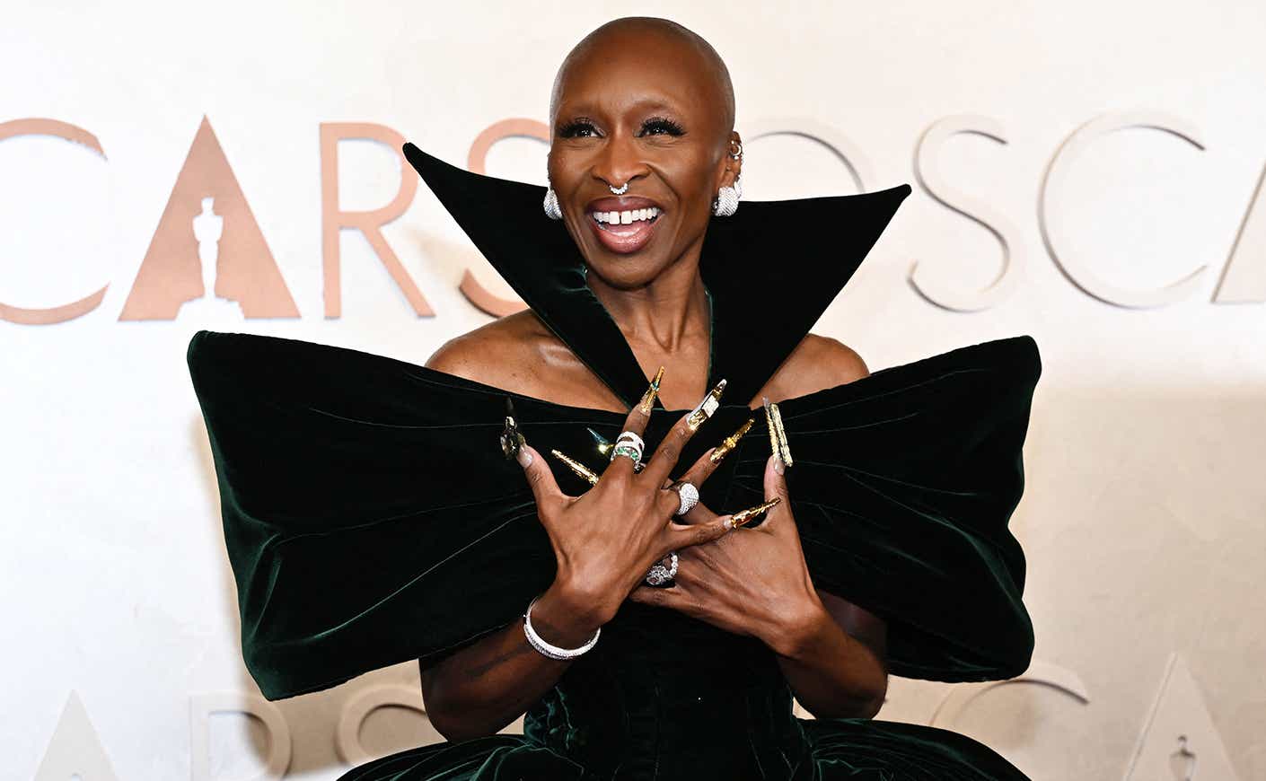 Cynthia Erivo at the Oscars red carpet in a gown with dramatic off-the-shoulder silhouette and a high collar.