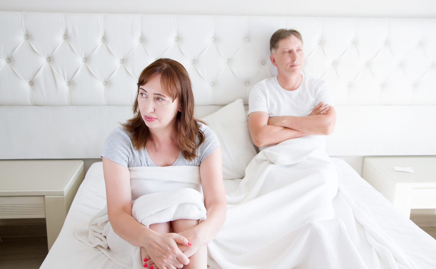Middle-aged couple sitting in bed