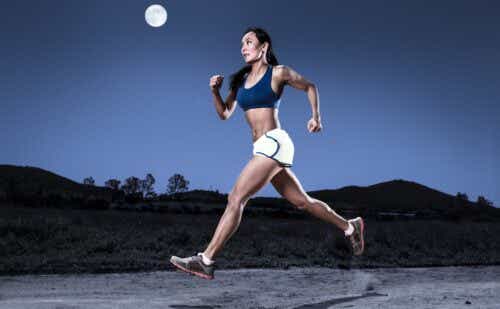 Female athlete runs under large full moon